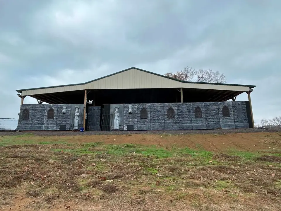A large open-sided barn building with a metal roof