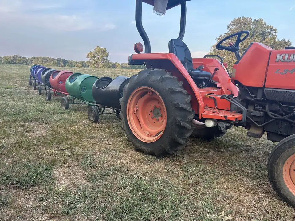 A red tractor pulling the barrel train
