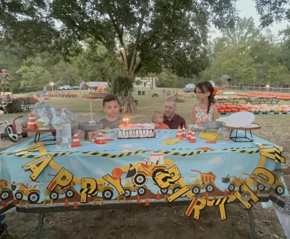 Children at a birthday party table with a construction-themed banner
