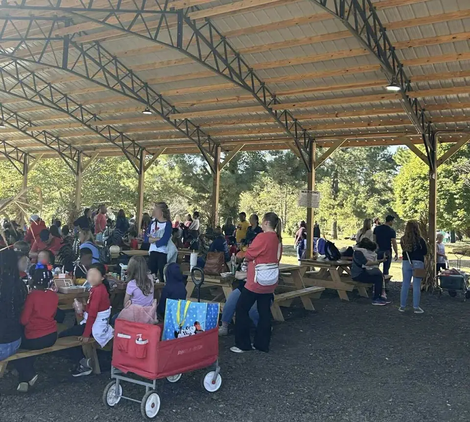 A crowd at picnic tables under the covered pavilion