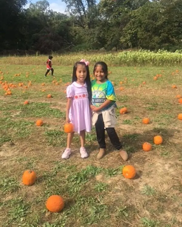 Two girls standing in the pumpkin patch