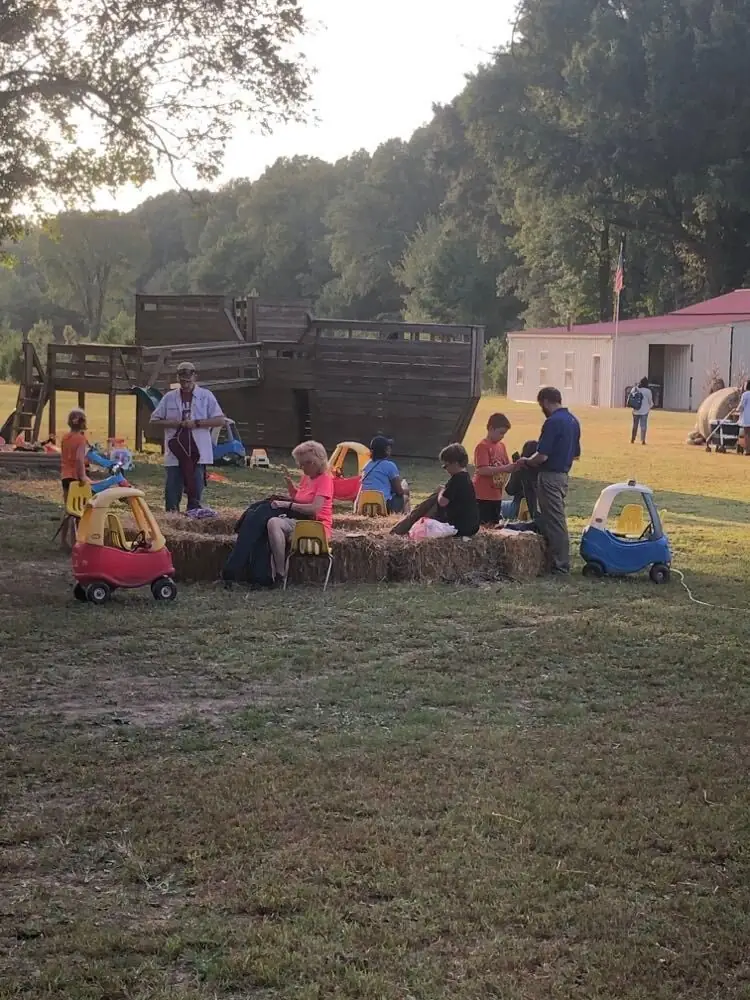 Kids and families in the playground area by the wooden ship