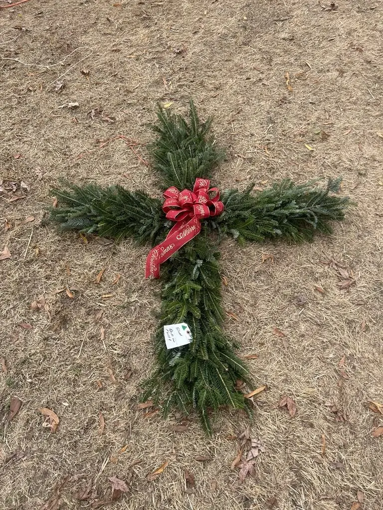 An evergreen cross with a red bow